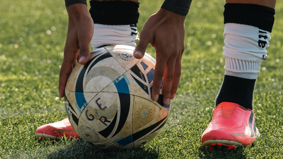 Pair of football boots on sand