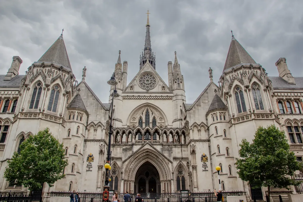 Exterior of the Royal Courts of Justice in London with cloudy skies.